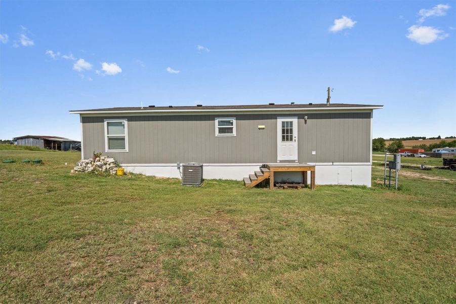 Rear view of property with a yard