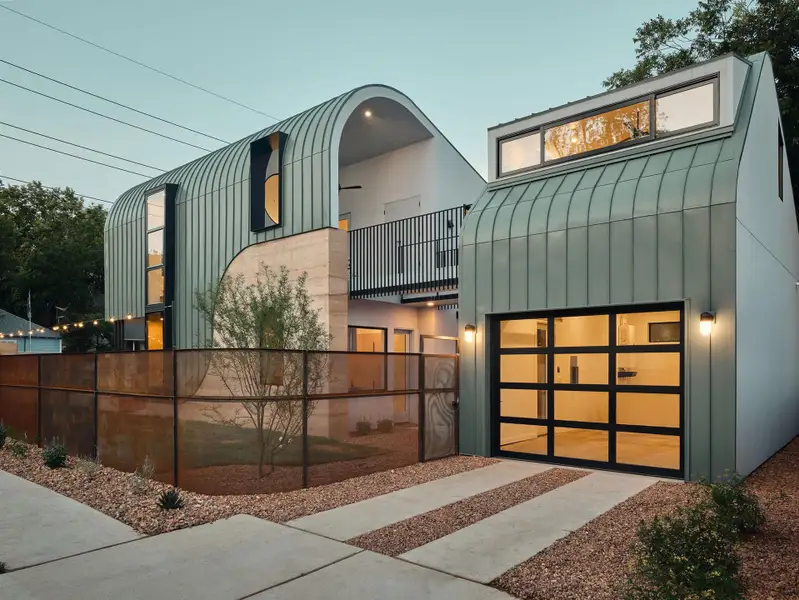 Modern Rammed Earth home featuring a detached guest suite/home office with it’s own bathroom above the garage, and a curved seam metal roof Modern Rammed Earth home featuring a detached guest suite/home office with it’s own bathroom above the garage, and a curved seam metal roof