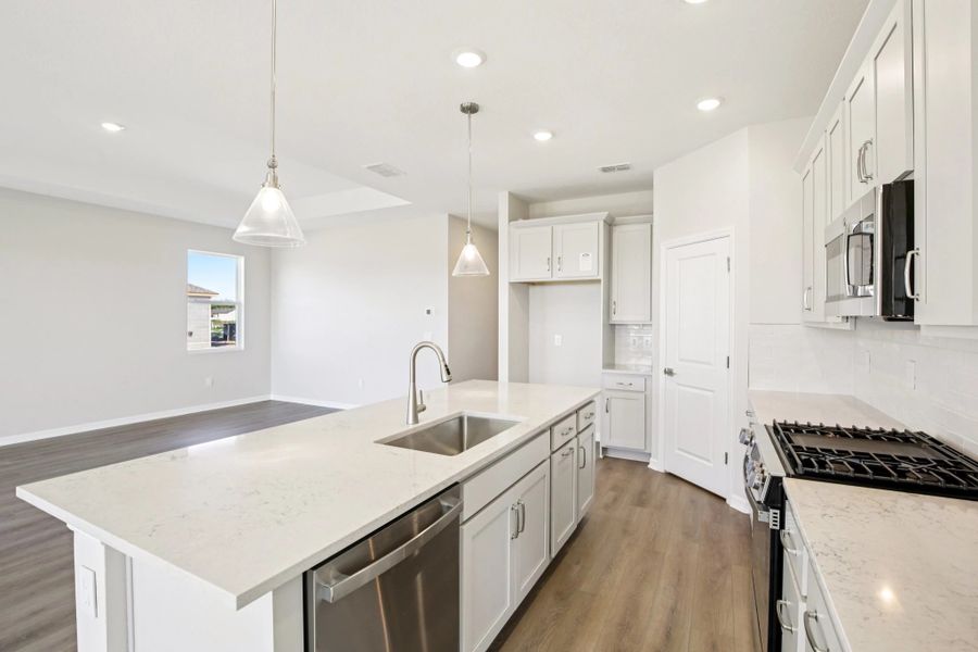 Large island with sink overlooking the family room featuring AW Collection® Milan
