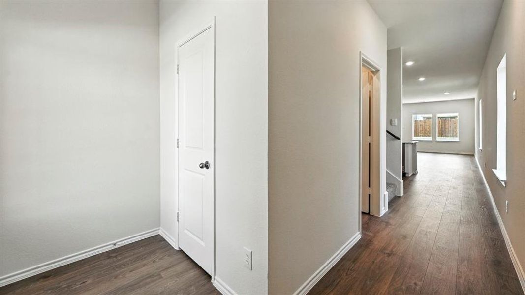 Hallway featuring wood-finish flooring, recessed lighting, and white baseboards
