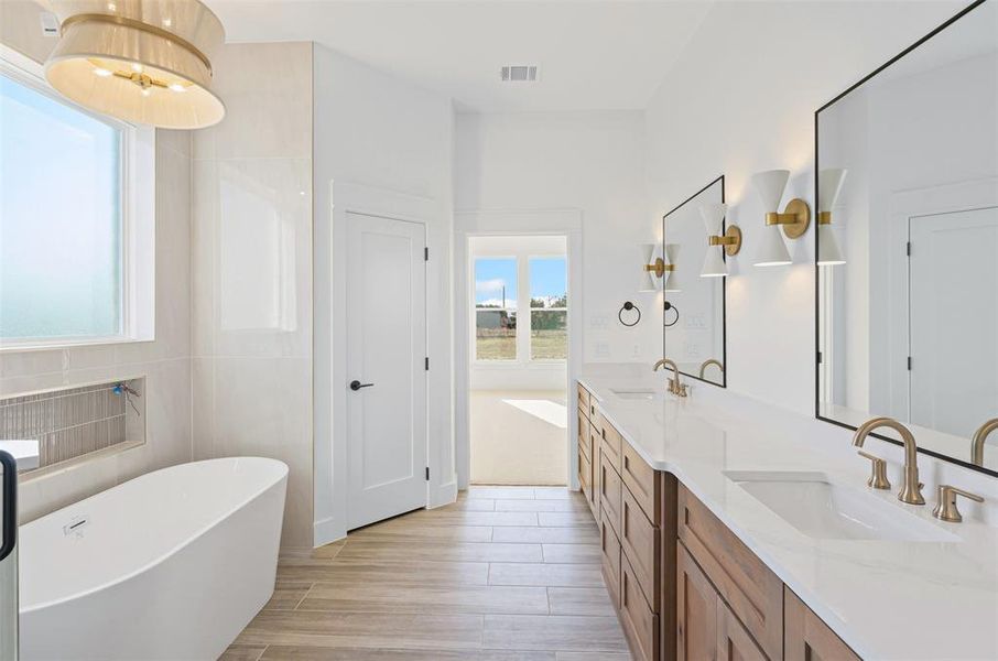 Bathroom featuring a washtub, wood-type flooring, vanity, and tile walls