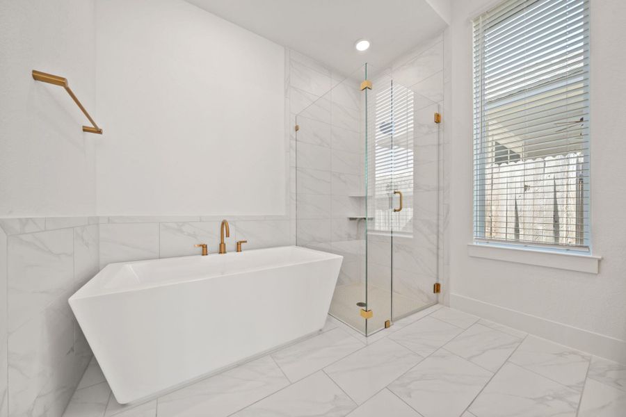 Bathroom with marble finish floors, a soaking tub, a marble finish shower, tile walls, and recessed lighting