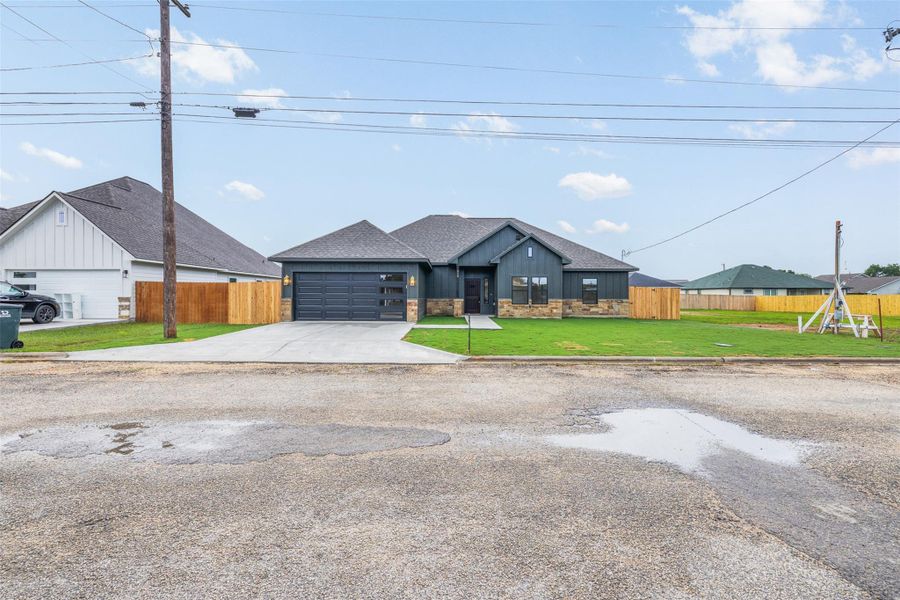 A newly constructed residence features modern dark siding and a prominent two-car garage. A newly constructed residence features modern dark siding and a prominent two-car garage.