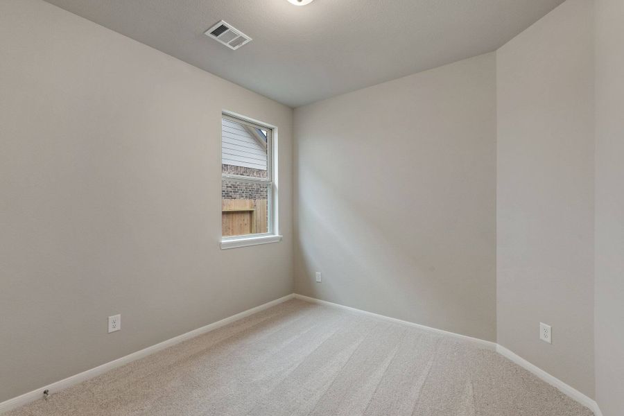 The third bedroom features plush carpet, fresh paint, closet, and a large window that lets in plenty of natural lighting.