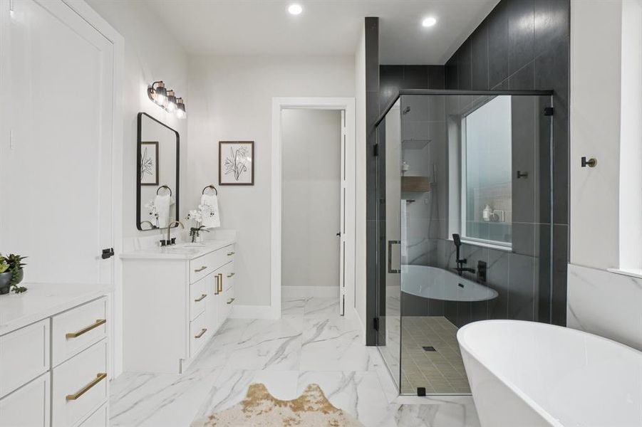 Full bath featuring a freestanding bath, a stall shower, vanity, recessed lighting, and light marble finish floors
