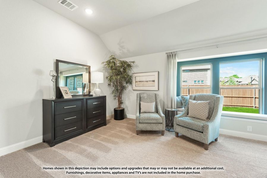 Bedroom sitting area with vaulted ceiling, dark dresser, two accent chairs, and large windows overlooking backyard Bedroom sitting area with vaulted ceiling, dark dresser, two accent chairs, and large windows overlooking backyard