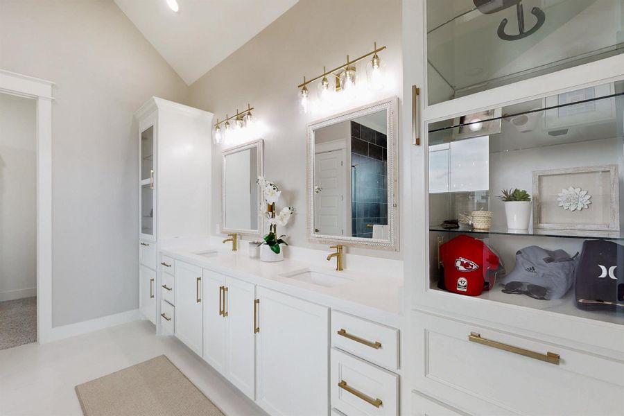 Custom shelving, tile floors, lots of light, and vaulted ceilings make this sophisticated retreat in the primary bathroom relaxing, and inviting.