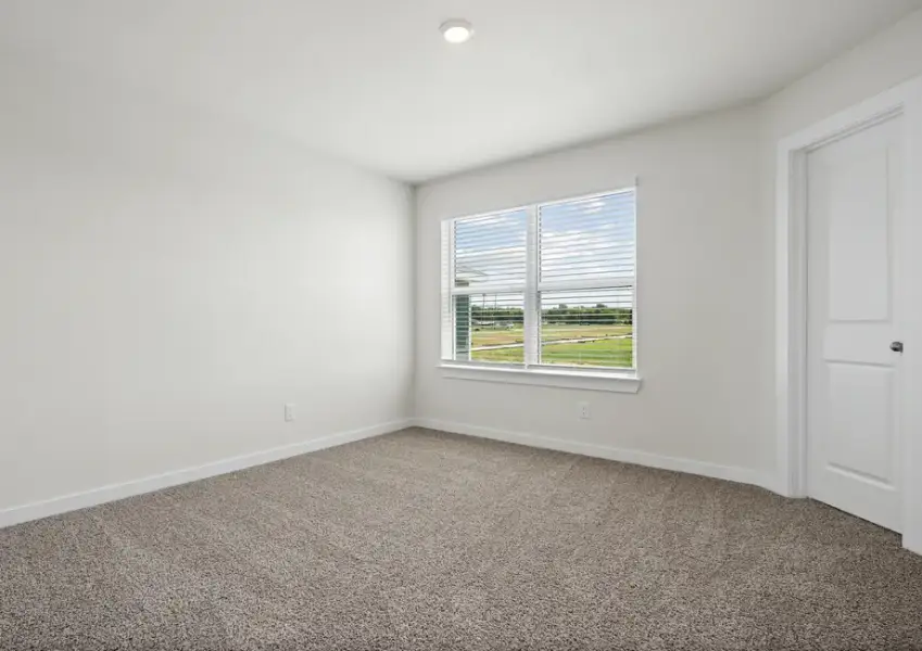 Incredible secondary bedroom with large window and a walk-in closet.