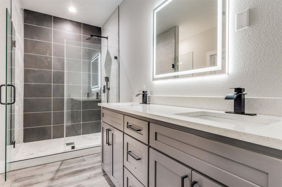 Bathroom featuring hardwood / wood-style floors, vanity, and walk in shower