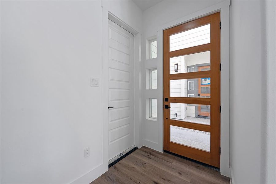 The beautiful modern front door and sidelights make entry into the home inviting. The two-car garage is on the left.