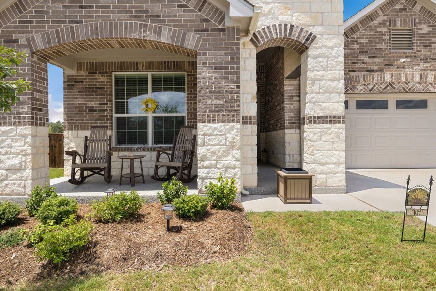 Doorway to property with brick siding, a garage, stone siding, and driveway Doorway to property with brick siding, a garage, stone siding, and driveway