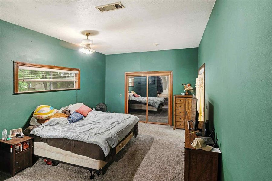 Bedroom with carpet flooring, a ceiling fan, and a textured ceiling Bedroom with carpet flooring, a ceiling fan, and a textured ceiling
