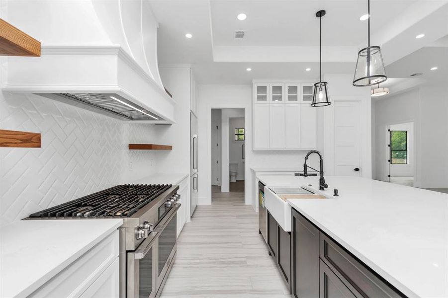 The kitchen has a clean, bright aesthetic with a herringbone backsplash and wood accents.