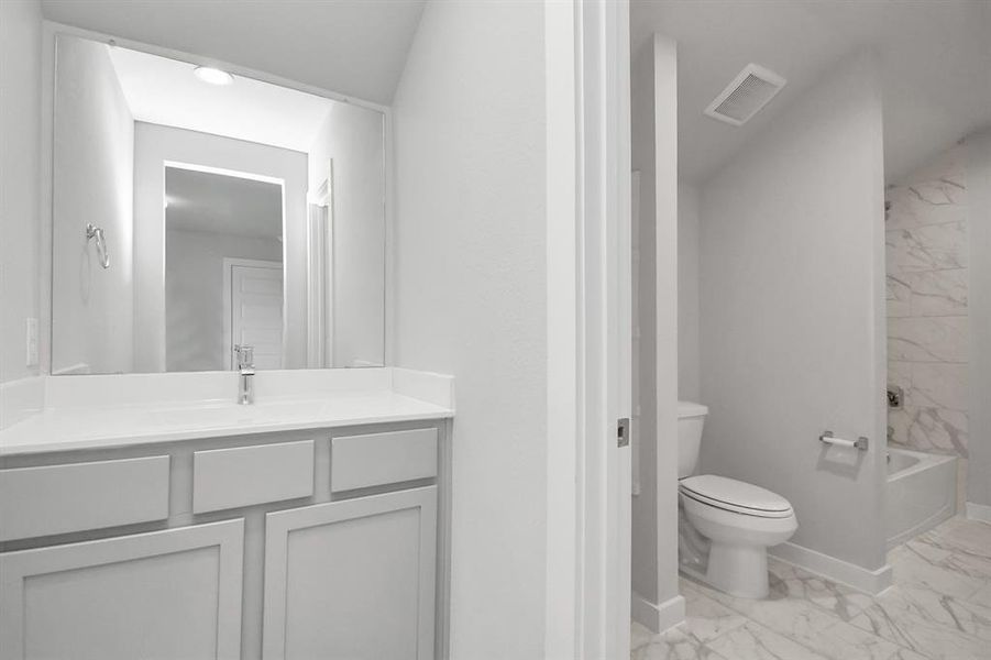 Experience convenience in the secondary bathroom, designed for Jack and Jill arrangements, now with a separate vanity area. Sample photo of completed home with same plan. Actual colors and selections may vary.