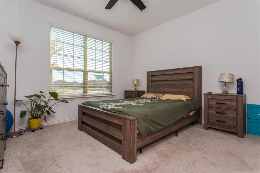 Bedroom with ceiling fan, light carpet, and lofted ceiling