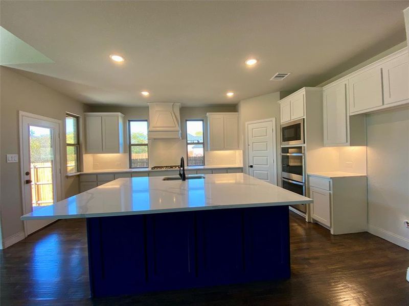 This huge custom Navy Blue island looks like a stylish furniture piece and has so much storage and countertop space