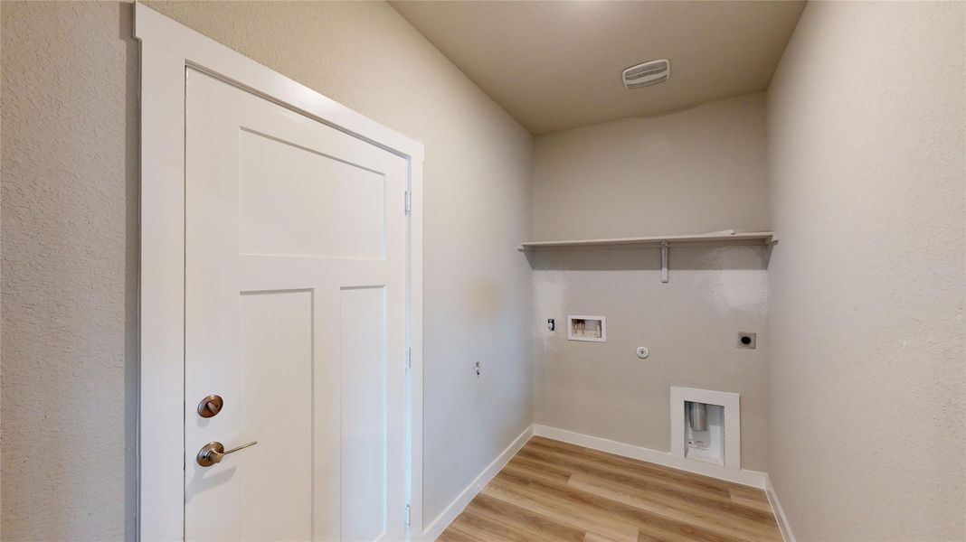 Laundry area featuring hookup for a gas dryer, electric dryer hookup, light wood-type flooring, hookup for a washing machine, and a textured wall