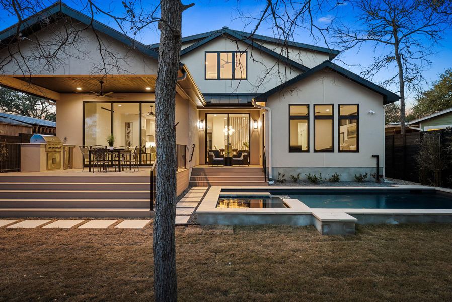Back of house featuring an outdoor kitchen / dining area, a patio, a ceiling fan, and an outdoor pool