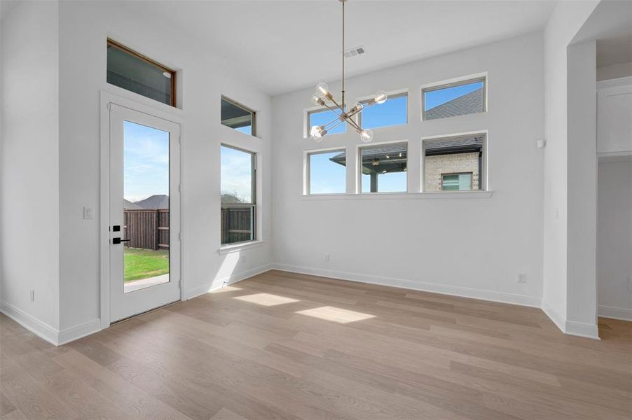 Unfurnished dining area featuring hanging lights and light wood-type flooring