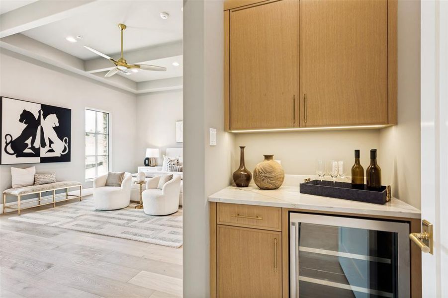 Coffee bar in the primary bedroom features a beverage refrigerator and custom cabinetry.