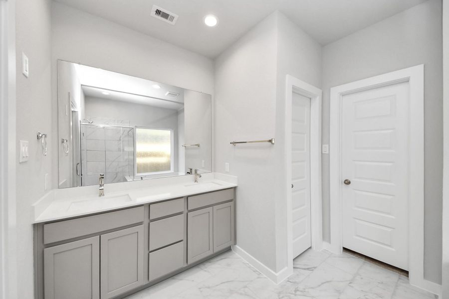 Elevate your daily routine at the elegant vanity, now equipped with double sinks, light countertops, modern hardware, and beautiful recessed lights. Sample photo of completed home with similar floor plan. Actual colors and selections may vary. Elevate your daily routine at the elegant vanity, now equipped with double sinks, light countertops, modern hardware, and beautiful recessed lights. Sample photo of completed home with similar floor plan. Actual colors and selections may vary.