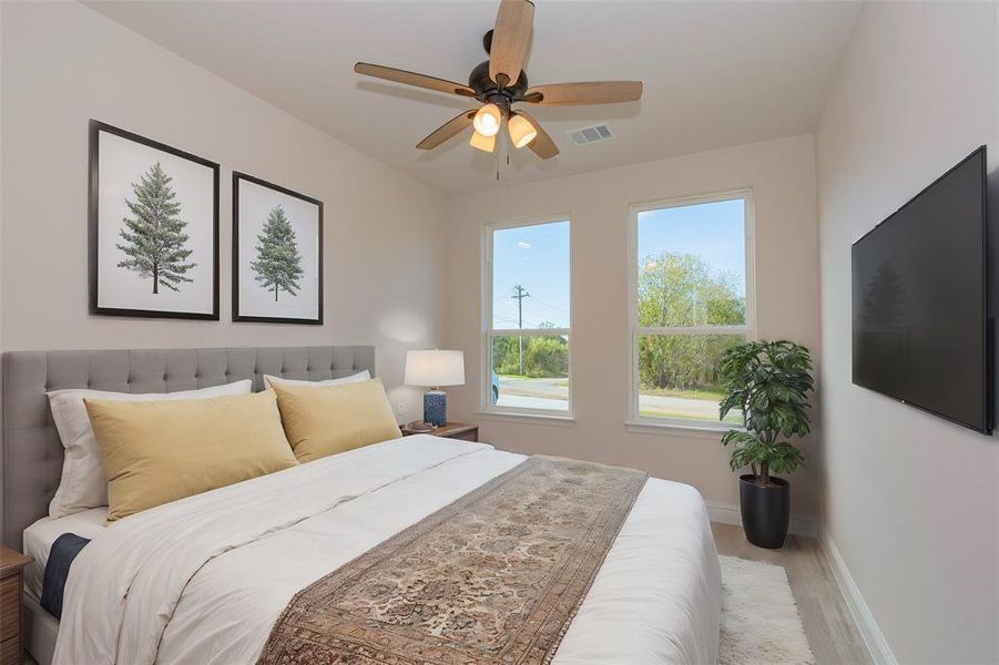 Bedroom with light hardwood / wood-style floors and ceiling fan