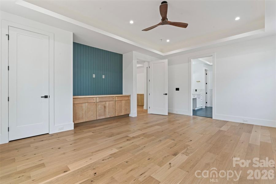 large Primary bedroom w/built in and accented tray ceiling