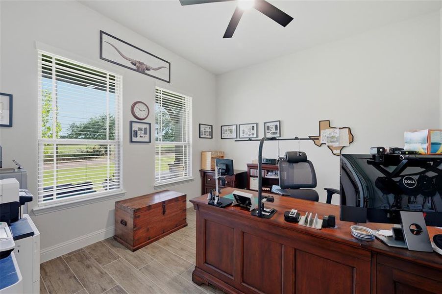 Spacious room with wood-finish flooring and a ceiling fan