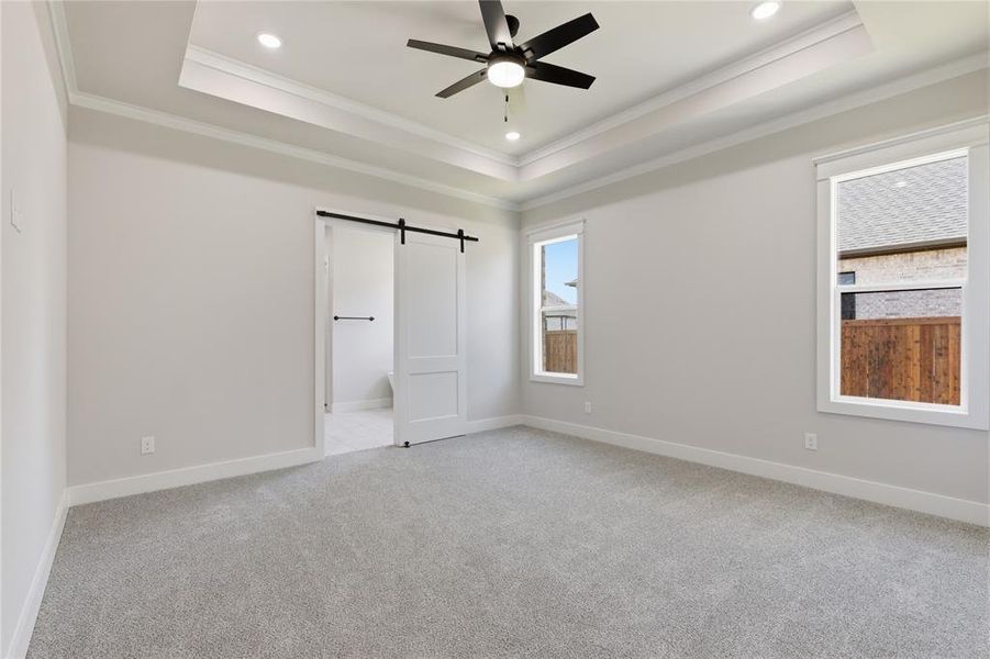Spacious room featuring light gray carpeting, recessed ceiling lighting, a contemporary ceiling fan, and two large windows