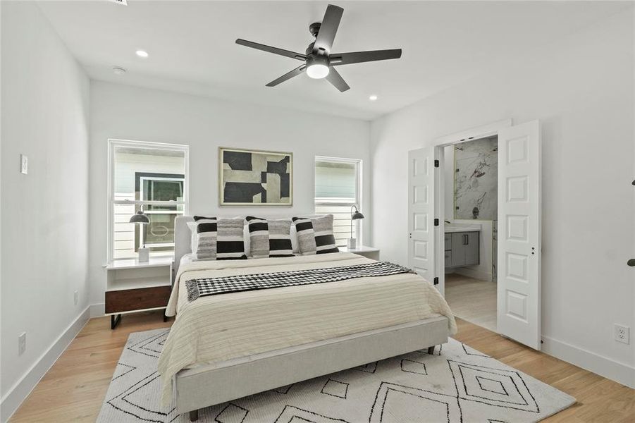 Bedroom featuring ceiling fan, connected bathroom, and light hardwood / wood-style floors