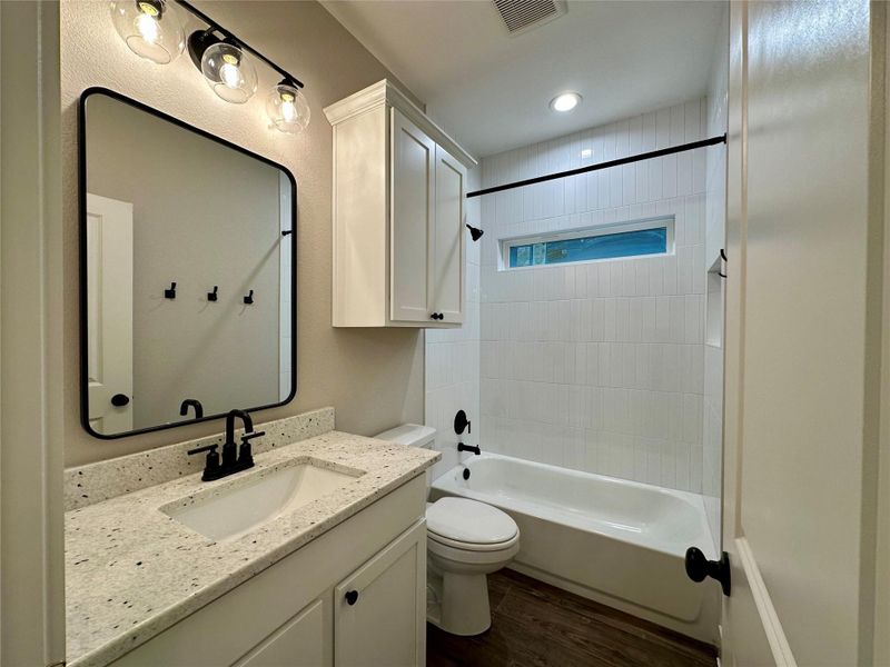 Full bathroom featuring wood finished floors, vanity,  shower combination, and recessed lighting