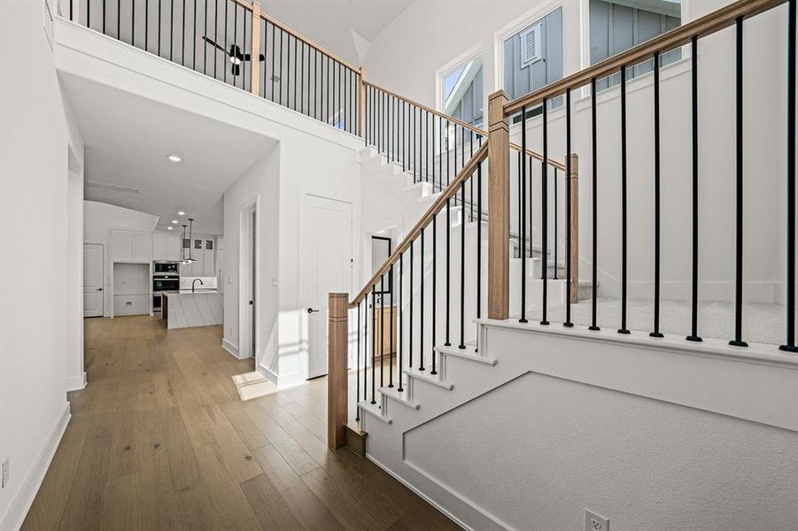 Entryway with hardwood / wood-style floors, a high ceiling, stairs, and recessed lighting