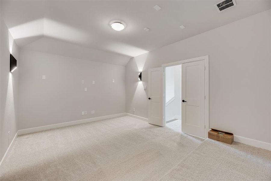 Bonus room featuring light carpet and vaulted ceiling