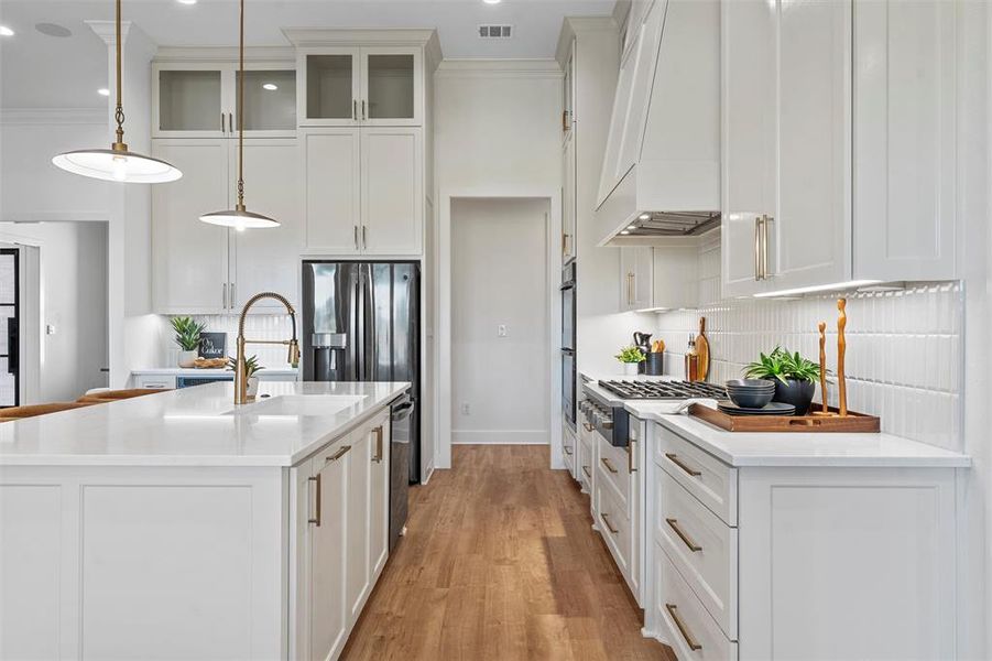 Kitchen with custom range hood, light countertops, white cabinets, tasteful backsplash, and ornamental molding
