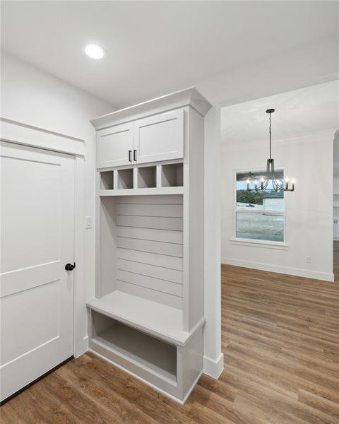 Mudroom with hardwood / wood-style floors and an inviting chandelier