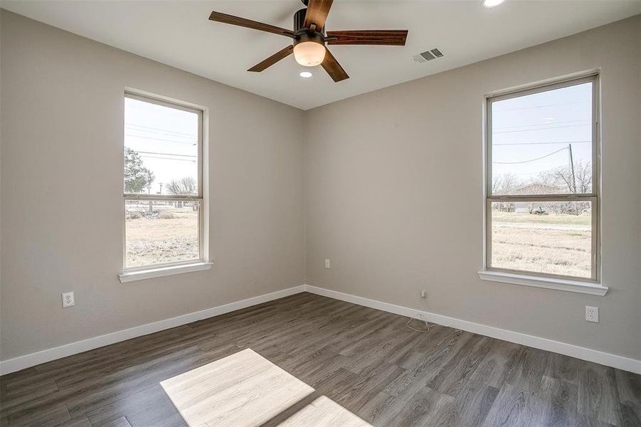 Empty room with plenty of natural light and dark hardwood / wood-style floors