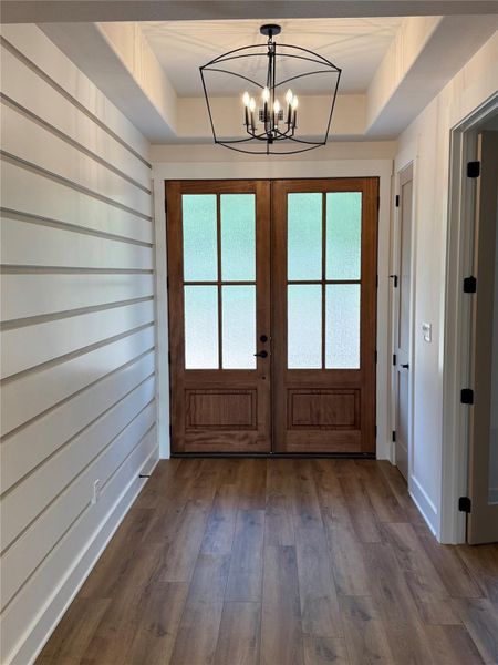 Double mahogany front door opens to an inviting entryway with french door entry to the study.