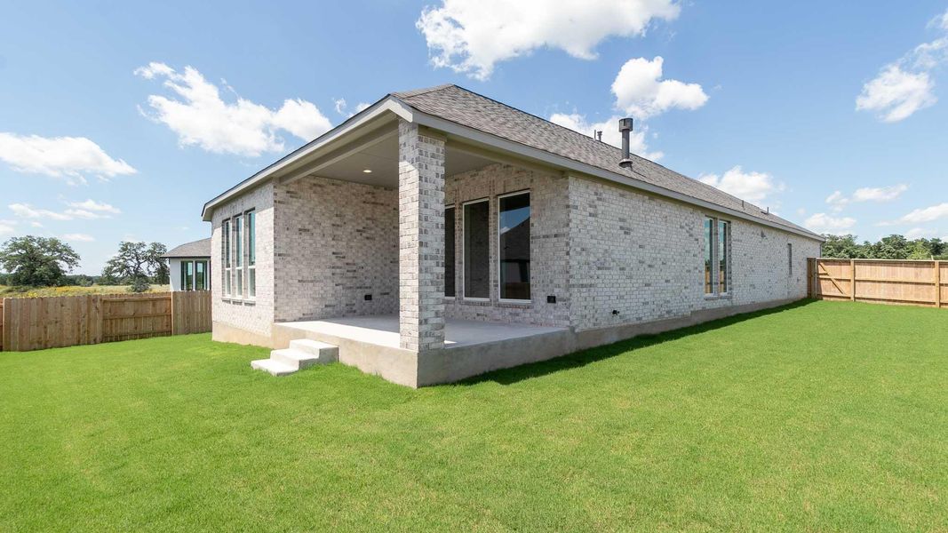Back of house with brick siding, a patio area, and a fenced backyard