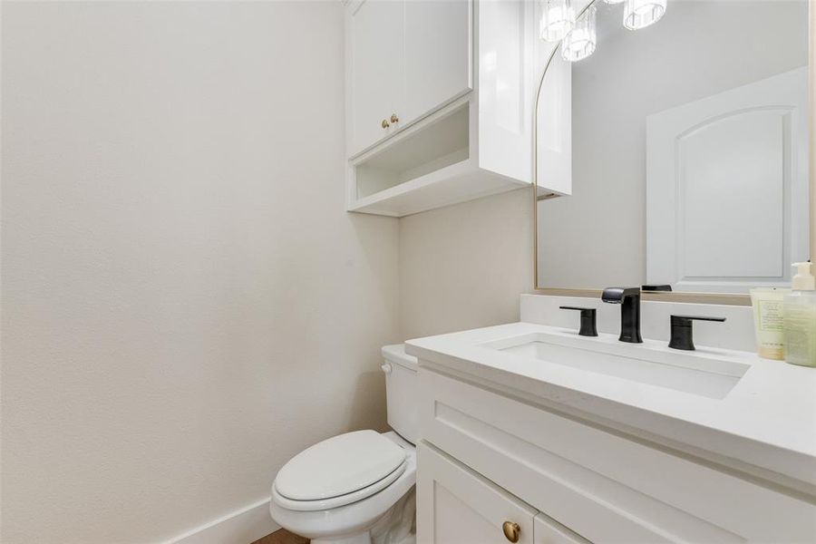 White vanity with an integrated rectangular sink, matte black faucet, and white countertop