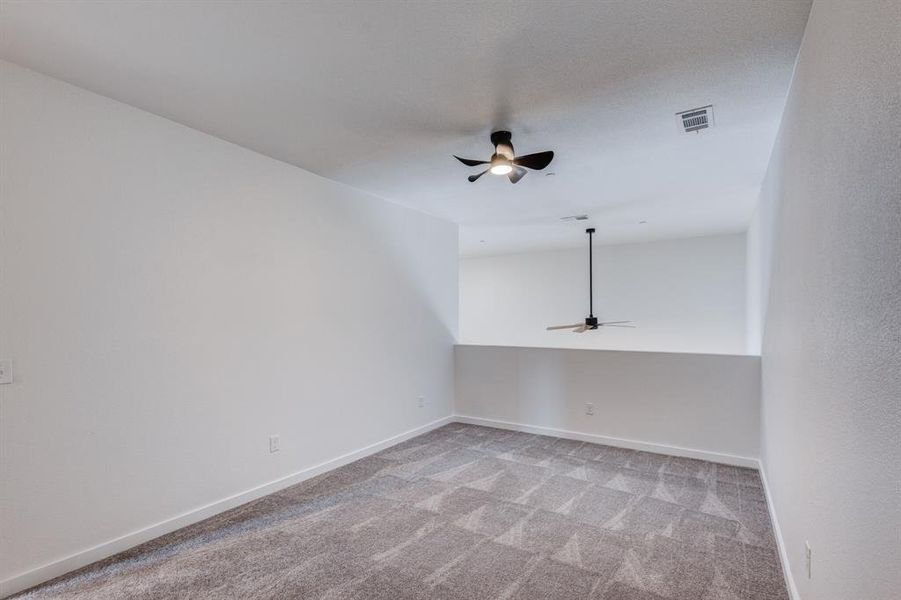 Bonus room with light carpet and ceiling fan