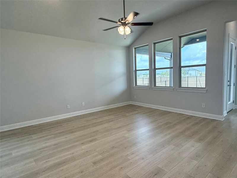 Spare room with light wood finished floors, vaulted ceiling, and a ceiling fan Spare room with light wood finished floors, vaulted ceiling, and a ceiling fan