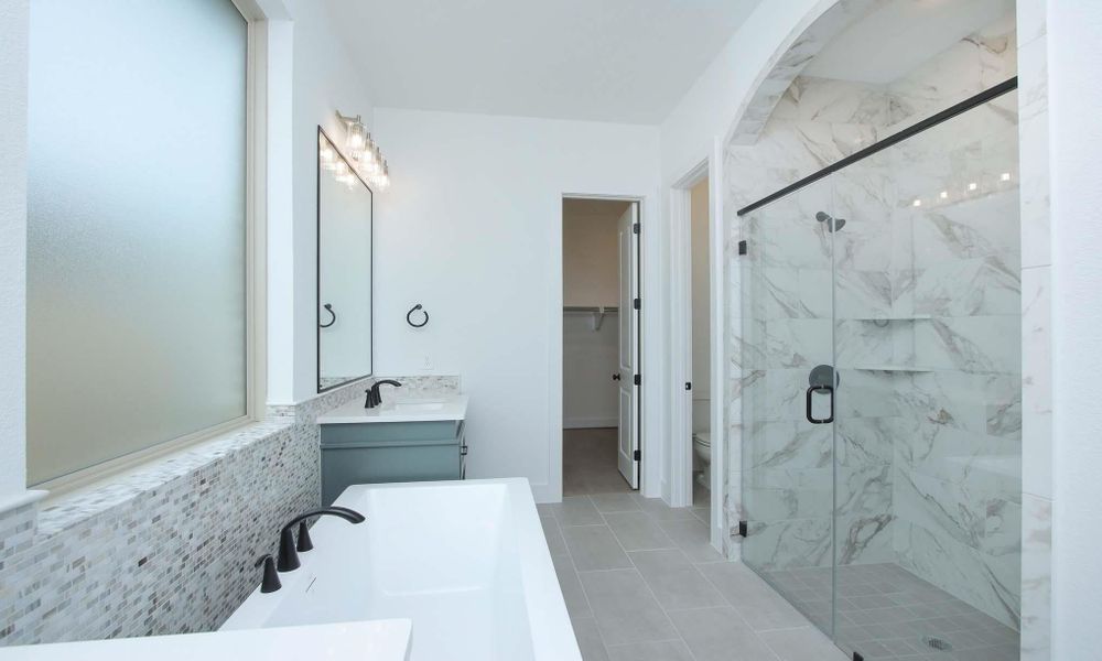 Full bath with a marble finish shower, vanity, tile patterned flooring, and a spacious closet