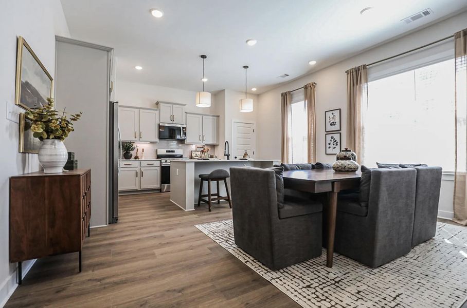 Open-concept living space with wood-finish flooring, recessed lighting, and a kitchen island with seating