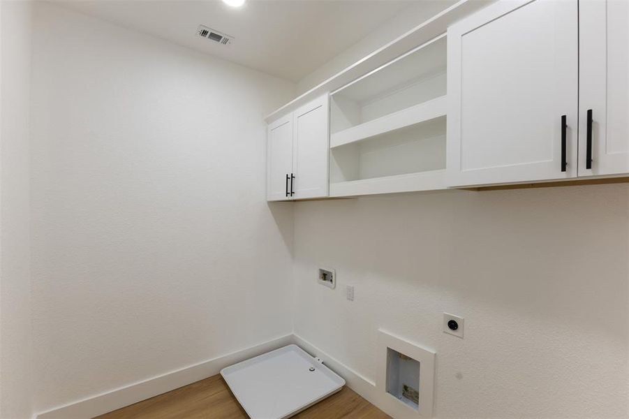 Laundry room with washer hookup, light wood-style flooring, electric dryer hookup, cabinet space, and gas dryer hookup