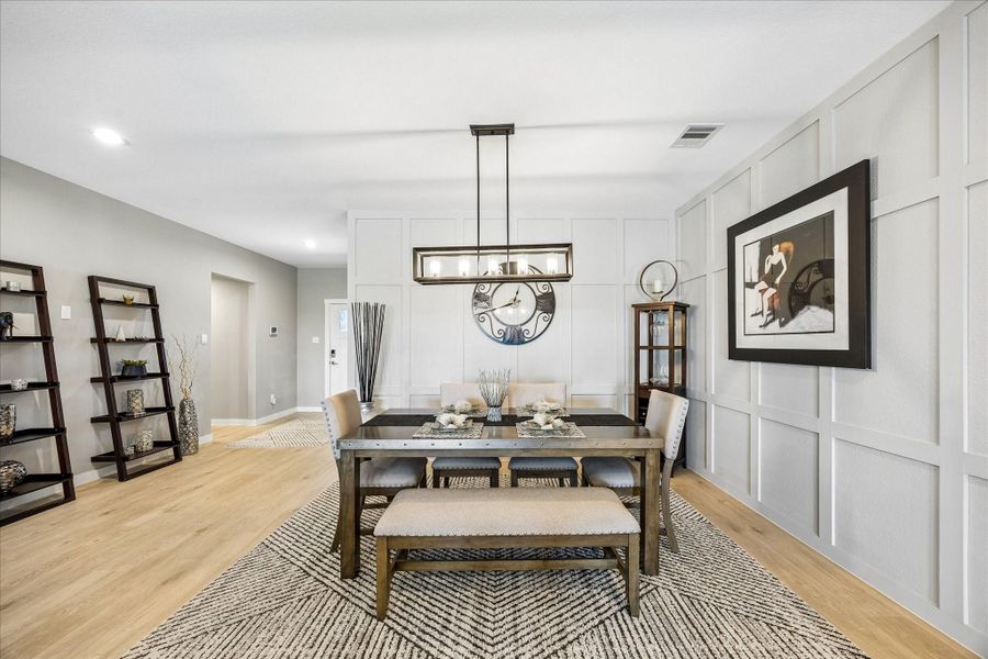 This is another view from the living room towards the dining room.  Upgraded elegant pendant lighting over the dining area and custom decorative wood accent wall in here as well.  All added after purchase.