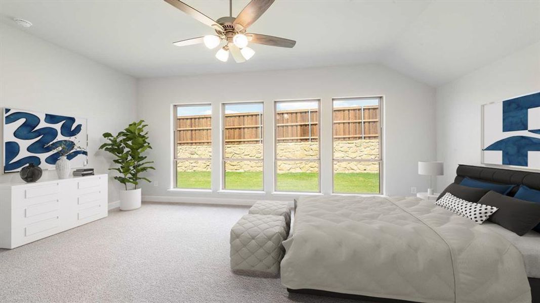 Carpeted bedroom with ceiling fan and vaulted ceiling