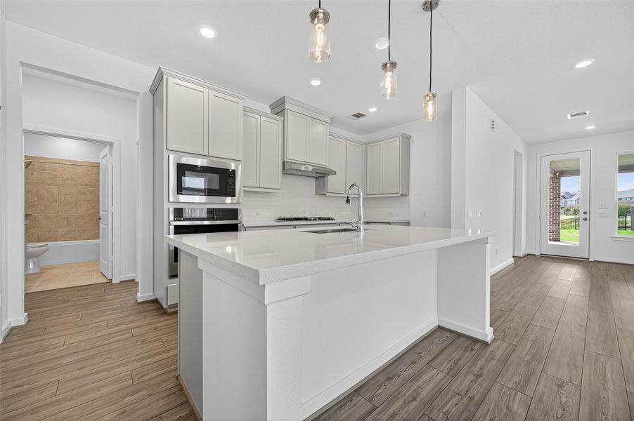 The expansive countertop island offers plenty of workspace and seating, making it a perfect spot for cooking, casual dining, or gathering with friends and family.