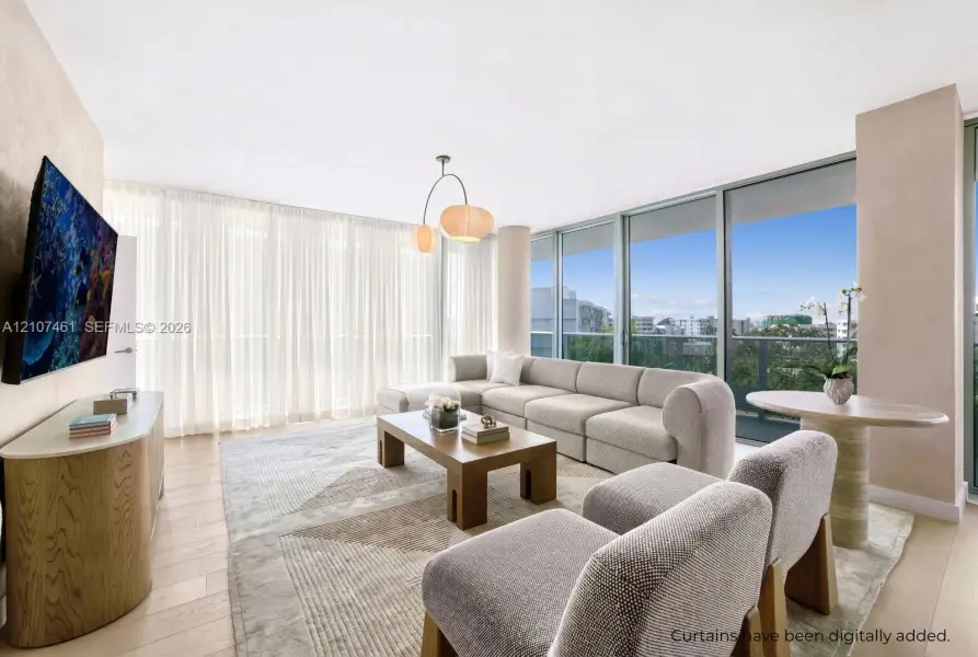 Living area featuring floor-to-ceiling glass windows, wood-finish flooring, and a contemporary multi-bulb pendant light fixture Living area featuring floor-to-ceiling glass windows, wood-finish flooring, and a contemporary multi-bulb pendant light fixture