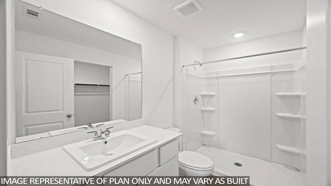 Full bath featuring a shower stall, vanity, and a spacious closet