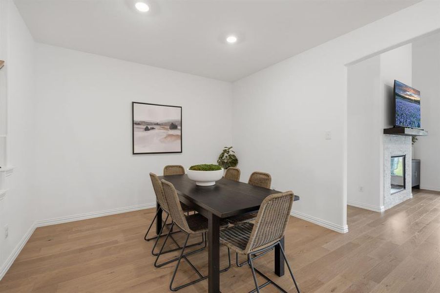 Open dining area with warm wood flooring and seamless flow to the living room and kitchen. Designed for everyday meals, holidays, and entertaining.